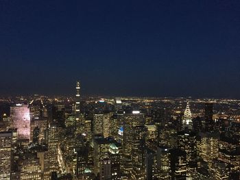 Illuminated cityscape against sky at night