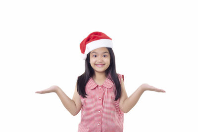 Portrait of smiling girl standing against white background