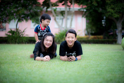 Siblings lying on grassy land in park