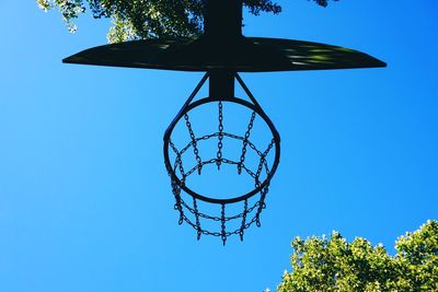 Low angle view of basketball hoop against clear blue sky