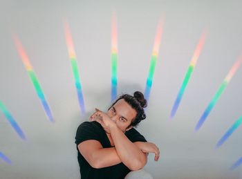 Portrait of smiling young woman standing against wall