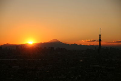 Silhouette tokyo sky tree and mt fuji against clear sky during sunset