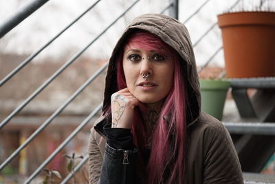 Portrait of woman with pink hair and hooded shirt