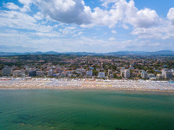 Aerial view of city buildings against cloudy sky