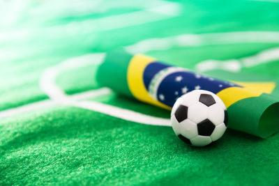 Close-up of small soccer ball with flag on green textile
