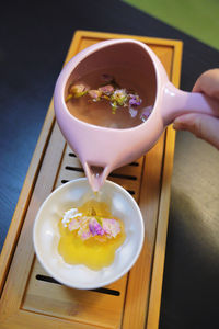 Close-up of hand holding dessert on table