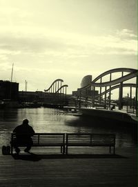 Pier on river against cloudy sky