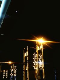 Low angle view of illuminated lights against sky at night
