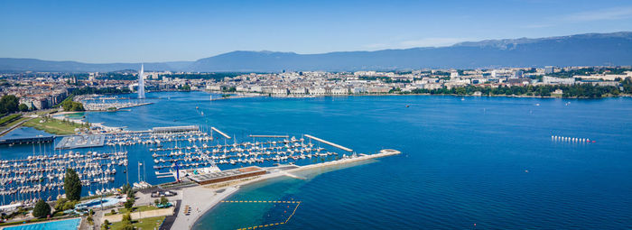 High angle view of city by sea against sky