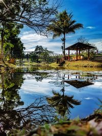 Scenic view of lake by trees against sky