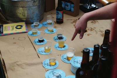 Cropped image of person pointing on beer glasses on table