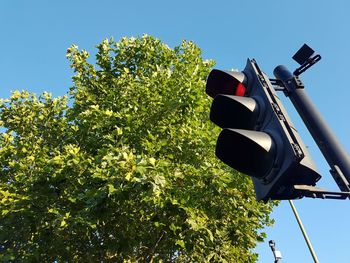 Low angle view of road signal against clear blue sky