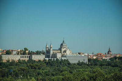 Royal palace and almudena cathedral on the horizon seen from the teleferico park of madrid, spain.