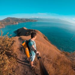 High angle view of man standing on mountain against sea