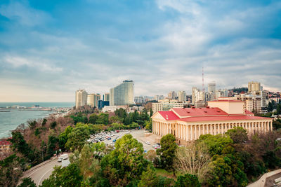 Buildings by sea against sky in city