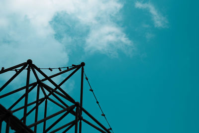 Low angle view of ferris wheel against blue sky