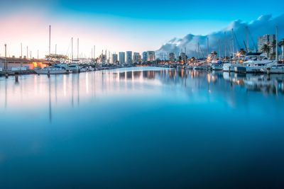 Scenic view of harbor against sky at dusk