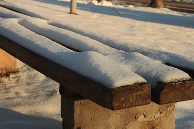 Close-up of snow covered log on field during winter