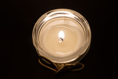 High angle view of lit candle against black background