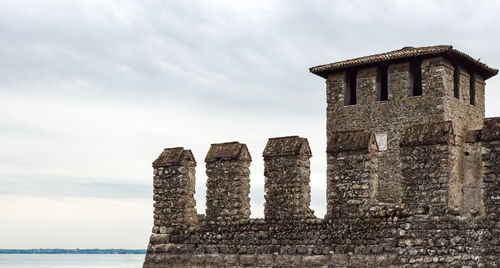 Low angle view of old building by sea against sky