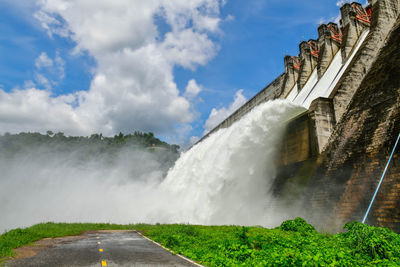 Scenic view of waterfall against sky