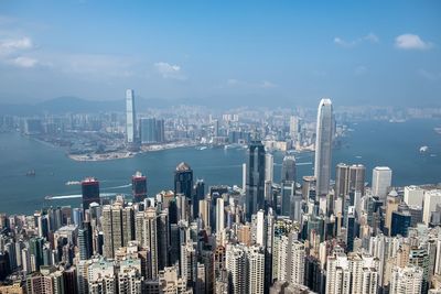 Aerial view of city by sea against sky