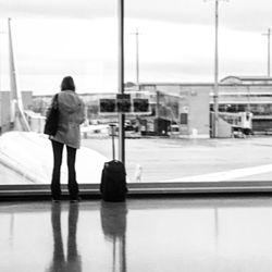 Rear view of man with umbrella on airport