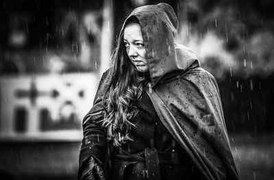 Portrait of smiling young woman standing in rain