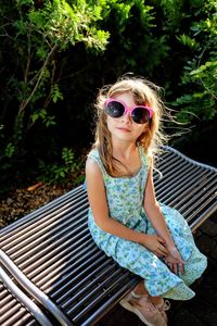 Portrait of woman wearing sunglasses sitting outdoors