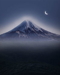 Scenic view of snowcapped mountains against sky at night