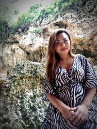 Portrait of smiling young woman on rock