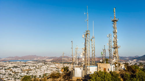 View of telecommunication mast tv antennas at sunrise on mountain with city on background. antenna