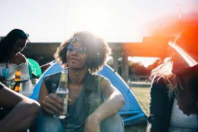 Man drinking alcohol while sitting with friends during event