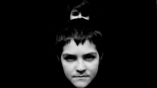 Portrait of young man against black background