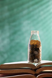 Coins in bottle on open book