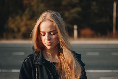 Portrait of beautiful young woman on road