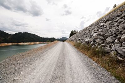 Empty road against cloudy sky