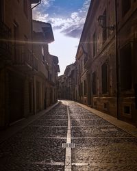 Empty narrow alley along buildings