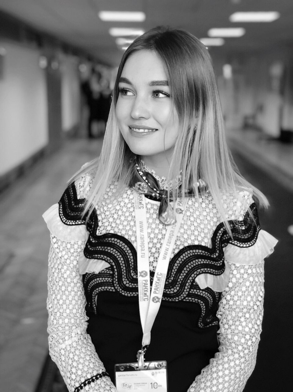 PORTRAIT OF SMILING YOUNG WOMAN STANDING AGAINST BUILDING