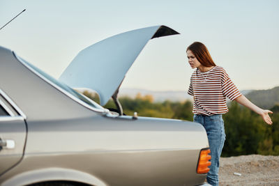 Rear view of woman holding car
