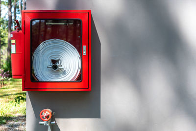 Close-up of red telephone booth against wall