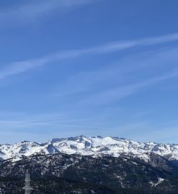 Scenic view of snowcapped mountains against blue sky