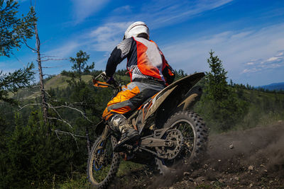 Enduro motorcycle racer riding on mountain trail