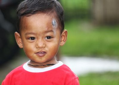 Close-up portrait of cute boy standing outdoors