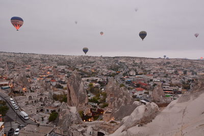Hot air balloons flying over buildings in city