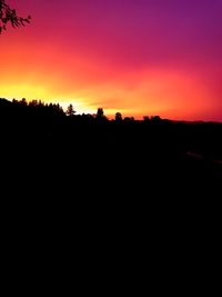 Silhouette landscape against sky at sunset