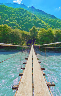 Hanging bridge over summer mountain river in sochi