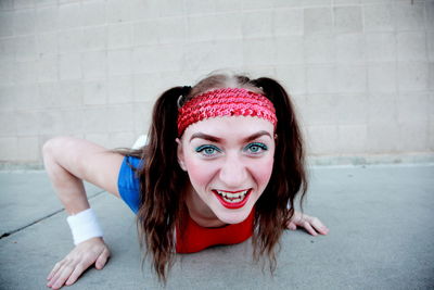 Portrait of cheerful teenage girl lying on street