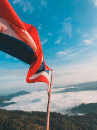 Low section of flag on mountain against sky