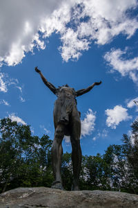 Low angle view of statue on tree against sky